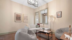A living room with a gray sofa, a coffee table, and a patterned floor.