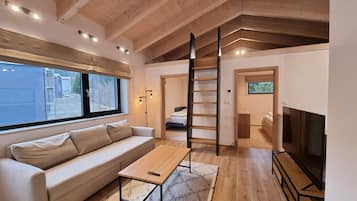 Departamento Deluxe, 2 habitaciones | Área de sala de estar | Televisión de pantalla plana