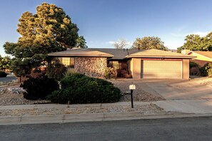 A residential house with a stone facade, a garage, and a well-maintained front yard.