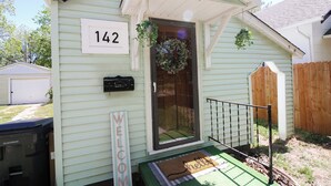 Una casa con un cartel con el número 142, un felpudo y un adorno en la puerta.