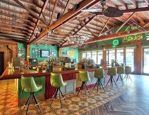 A bar with a rustic wooden ceiling and green walls, featuring a bar counter with stools and a neon sign. - A small, private bedroom & bathroom Little Havana in Miami A1 (Miami)