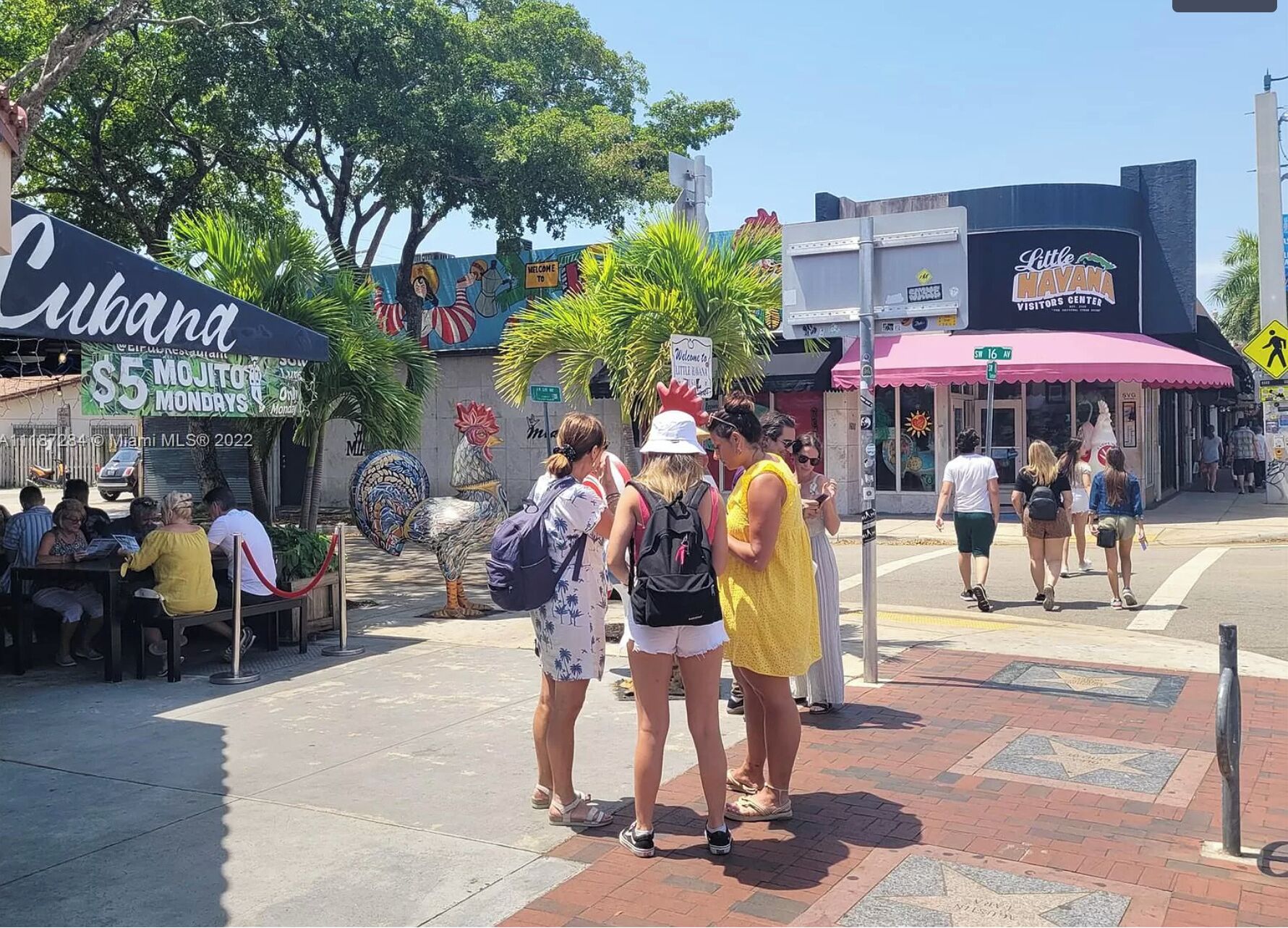 Straatbeeld met een 'Cubana' restaurant dat op maandagen mojito's voor 5 dollar aanbiedt.