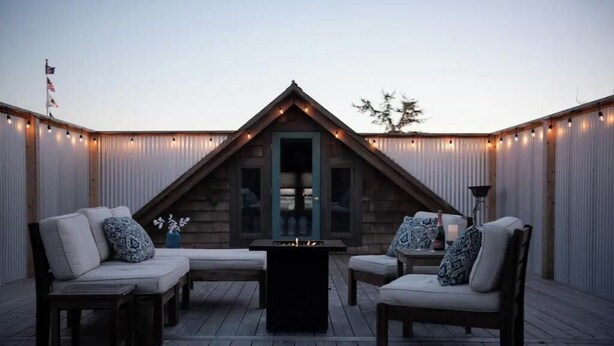 A cozy outdoor seating area with a fire pit, surrounded by wooden deck and metal walls. - Plaza Perch~Downtown~Walkable (Arcata)
