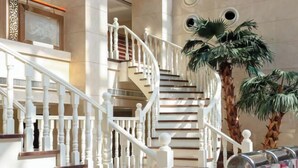 Un magnifique escalier avec des rampes blanches et un plancher en bois poli, menant à un niveau supérieur.