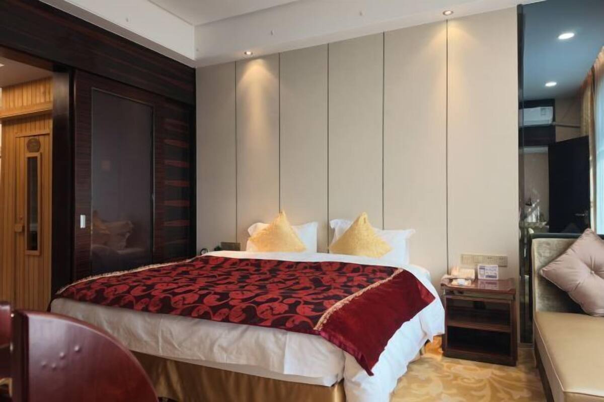 Une chambre d’hôtel avec un grand lit, un bureau, une chaise et un téléviseur.