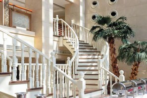 Un magnifique escalier, doté de rampes blanches et de marches en bois, menant à un niveau supérieur.