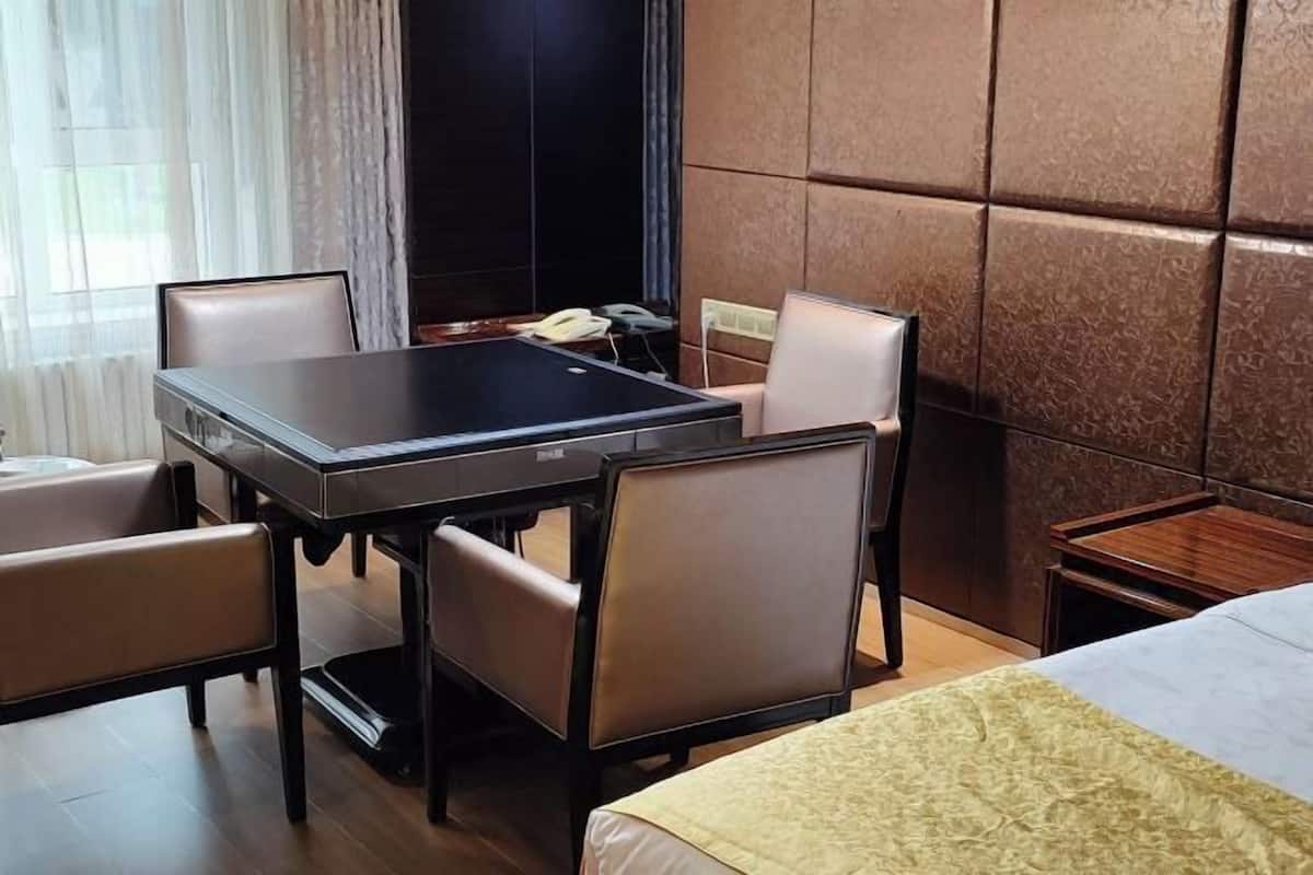 Une chambre d’hôtel avec un lit, un bureau et deux chaises.