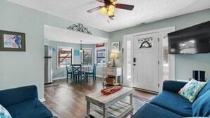 A living room with a ceiling fan, a TV, and a dining area with a table and chairs. - 1802A Ocean Lakes Pet Friendly Golf Cart⛱️🏝️🩱🌊👙☀️🐚 (Myrtle Beach)