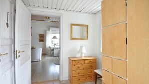 Ein Flur mit einem Holzschrank, einem Spiegel und einem Stuhl.