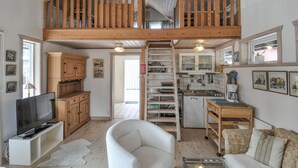 Ein Loft-Wohnraum mit Küche, Essbereich und Fernseher.