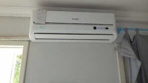 A white air conditioning unit labeled 'Consul' mounted on a wall above a window. - Hotel Ita Avenida (Itaborai)