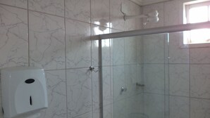 A bathroom with marble tiles, a glass shower enclosure, and a hand dryer. - Hotel Ita Avenida (Itaborai)