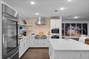A modern kitchen with stainless steel appliances, white cabinetry, and a large island. - Discount 30% - King Beds Sleep16+ Country Pool Paradise, Lake, Arcade, Theater (Azle)