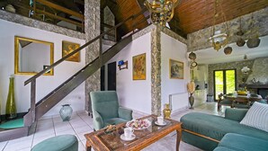 A spacious living area with a staircase, green sofas, a wooden coffee table, and a kitchen in the background. - Beautiful home in Donji Zvecaj with WiFi (Donji Zvecaj)