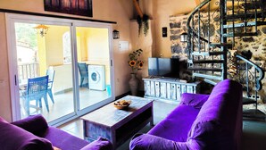 Una sala de estar acogedora con un sofá, un televisor y una escalera.