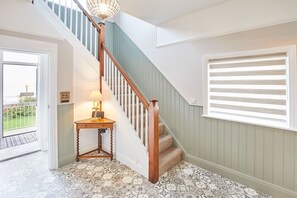 Un escalier avec une rampe en bois et un luminaire au sommet.