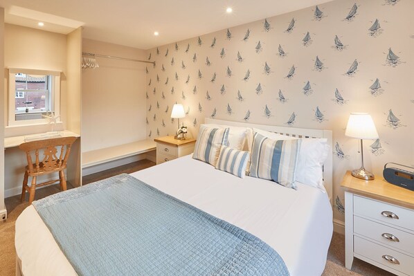 A bedroom with a bed, bedside tables, a chair, a window, and a wall with sailboat wallpaper. - Stunning, dog friendly , Parking 2 cars in Whitby (Whitby)