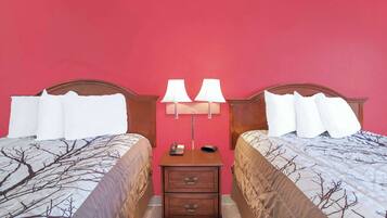 A hotel room with two beds, a nightstand with lamps, and a telephone.