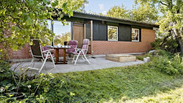 A small brick house with a patio area featuring a table and two chairs. - 3 bedroom lovely home in Høng (Høng)