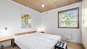 A bedroom with a large bed, a bench, a stool, a painting, and a window with a view of trees. - 3 bedroom lovely home in Høng (Høng)
