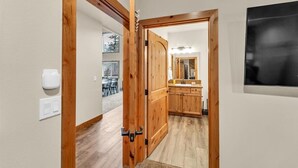 A wooden door leading to a kitchen with wooden cabinets and a countertop. - Cozy Chinook Cabin (Naches)