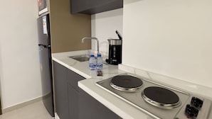 Eine moderne Küche mit integriertem Mikrowellenherd, Kühlschrank, Herd und Spüle.