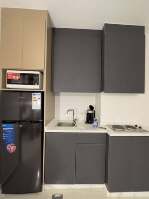 Eine Küche mit Mikrowelle, Kühlschrank, Spüle und Herd.