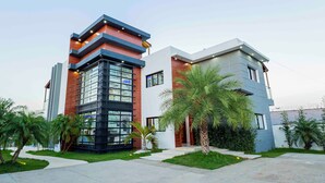 Un edificio moderno con una sección de esquina de vidrio y una fachada combinada de ladrillo y concreto.