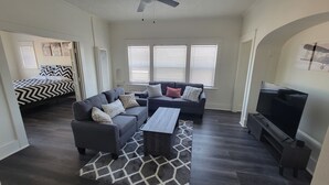 A compact living space with a sofa set, a coffee table, a TV, and a bed with patterned bedding. - Modern 2 bed 2 bath Paradise - Mins. from LAX & SOFI (Los Angeles)