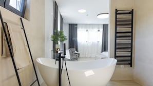 A modern bathroom with a freestanding bathtub, a towel rack, and a potted plant. - Awesome home in Kastel Stari with sauna (Kastel Stari)
