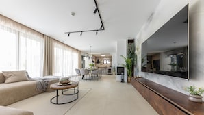 A modern living room with a sofa, coffee table, and dining area. - Awesome home in Kastel Stari with sauna (Kastel Stari)