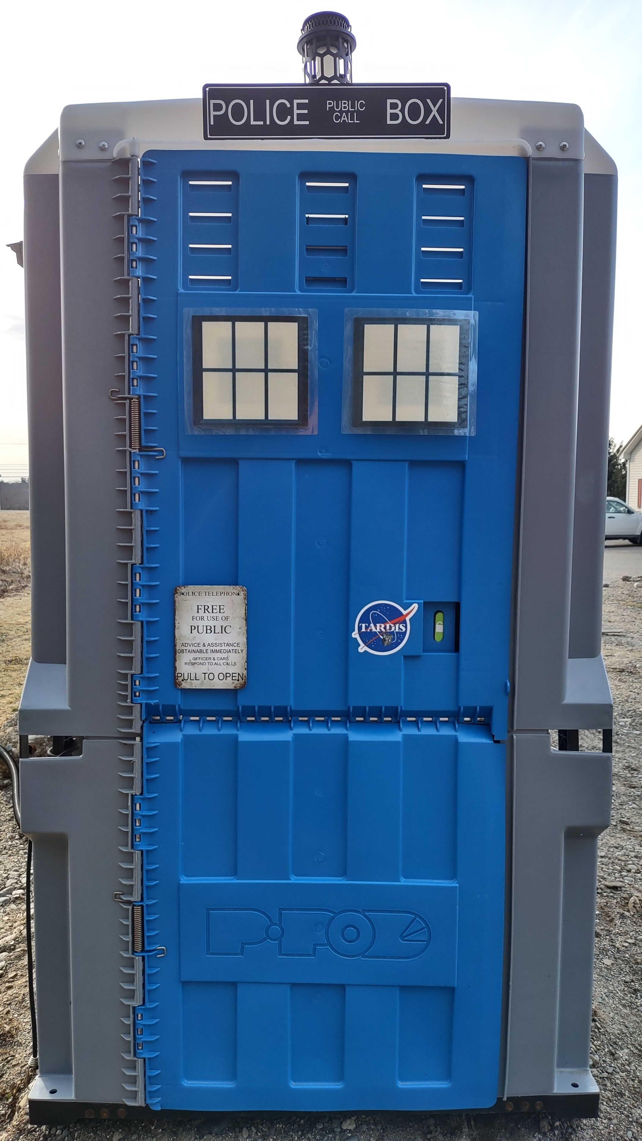 A police public call box with a TARDIS logo, a pull-to-open feature, and a sign indicating free police telephone use.