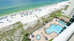 Un complexe hôtelier de bord de mer doté d’une piscine, de parasols et de chaises longues.