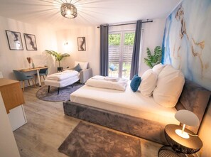 Une chambre à coucher moderne avec un lit, une table de chevet et un espace bureau.