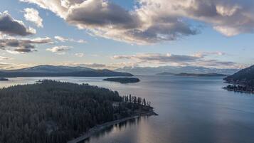 Vista panorâmica de um lago rodeado por colinas e montanhas arborizadas.