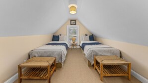 A small, cozy attic bedroom with two beds, a small table, and a lamp. - Monthly Rental - Crimson 4 BR Cabin By Tahoe Getaways - Walk Downtown Truckee (Truckee)
