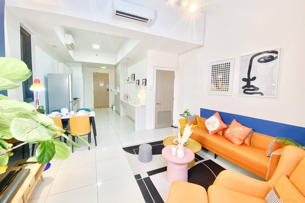 A modern living room with a sofa, a coffee table, and a dining area with chairs and a table.