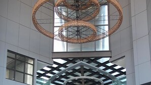 Un bâtiment moderne doté d’un atrium central, de plusieurs étages et d’un plafond circulaire remarquable.