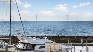 A marina with boats docked near a large bridge.