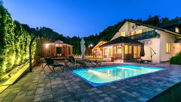 A swimming pool with lounge chairs, a covered seating area, and a house with a balcony. - Pet friendly home in Tuheljske Toplice with sauna (Tuheljske Toplice)