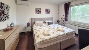 A neatly arranged bedroom with a large bed, a bedside table, a dresser, and a window with curtains. - Pet friendly home in Tuheljske Toplice with sauna (Tuheljske Toplice)