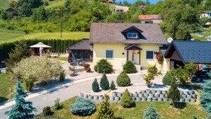 A two-story house with a tiled roof, surrounded by a well-maintained garden with various shrubs and a gravel driveway. - Pet friendly home in Tuheljske Toplice with sauna (Tuheljske Toplice)