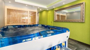 A spa room with a hot tub, wooden cabinets, a mirror, and a green wall. - Pet friendly home in Tuheljske Toplice with sauna (Tuheljske Toplice)