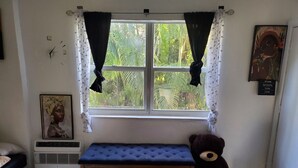 A room with a window, a clock, a bench, a teddy bear, a radiator, a framed picture, and a motivational quote on the wall. - 420 Friendly South Beach Miami  (Miami Beach)