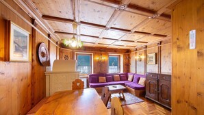 Un intérieur en bois avec une table à manger, un canapé violet et un meuble.