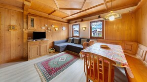 A wooden interior with a sofa, dining table, and cabinets. - Apartment 'Michaela A Vinigo' with Mountain View, Private Terrace and Wi-Fi (Vinigo)