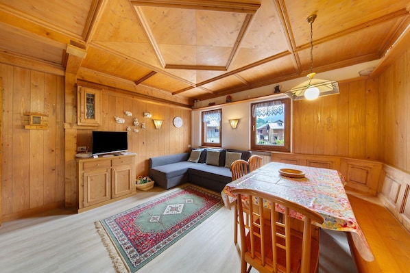 Un intérieur en bois comprenant un canapé, une table à manger et des placards.