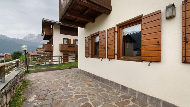 A stone-paved courtyard with wooden shutters, a balcony, and a mountain view in the background. - Apartment 'Michaela A Vinigo' with Mountain View, Private Terrace and Wi-Fi (Vinigo)
