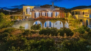 A modern house with a large patio, multiple windows, and a view of the surrounding landscape. - Country house "Agios Sostis" with a jacuzzi and close to the beach (Serifos)