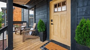 A wooden deck with two chairs and a small potted plant. - Central Loc*Luxury*Indoor Pool *Hot Tub *Dollywood (Pigeon Forge)